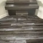 Southwind Colonial Plank Homestead Waterproof Flooring installed around piano