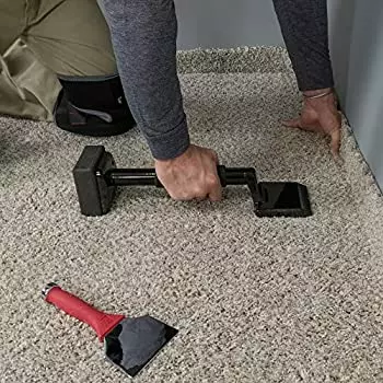 Man improperly installing carpet with no power stretcher